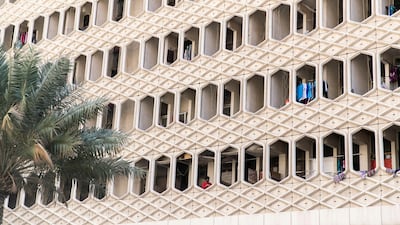 A man stands on his balcony in the Baniyas neighbourhood. Metro stations including Baniyas Square on the Green Line have closed and services will run through the underground station without stopping