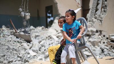 Palestinian children sit amid the rubble of buildings, destroyed during the 50-day war between Israel and Hamas, in the village of Khuzaa, southern Gaza strip. Said Khatib / AFP