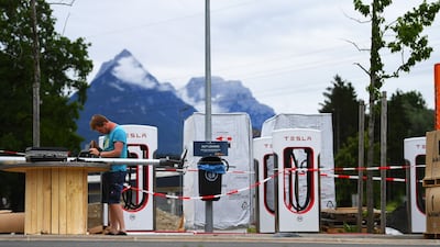A technician works on solar-powered lamp-posts at a Tesla charging site in Niederbreitenbach, Austria. Bloomberg