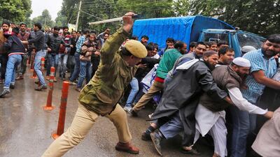 A policeman uses a baton to disperse demonstrators during a protest by government employees demanding their long pending arrears in Srinagar. Danish Ismail / Reuters