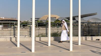 A man walks past the entrance to the Expo 2020 site in Dubai. Bloomberg