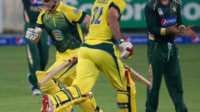 Australian batsmen Glenn Maxwell, right, and George Bailey run between wickets during the second One Day International (ODI) cricket match against Pakistan in Dubai on October 10, 2014. AFP PHOTO/ MARWAN NAAMANI