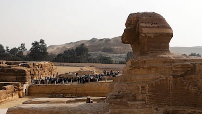 Visitors are seen next to the Sphinx at the Giza pyramids plateau in Egypt. Egypt can access $1.67bn in aid after the IMF completed its first review of the country's economic reform programme. Reuters.