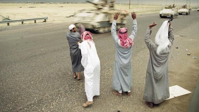 A group of Kuwaitis greet a convoy of Egyptians armored vehicles moving along a highway near Kuwait City in February 1991 as Kuwait is liberated. .(Sadayuki Mikamd / AP)
