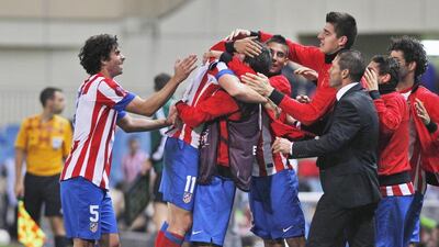 Atletico Madrid's Cristian Rodriguez, second left, celebrates his goal with team mates, and coach Diego Simeone, third right. Atletico are on the cusp of a Primer Liga title. AP Photo/Andres Kudacki