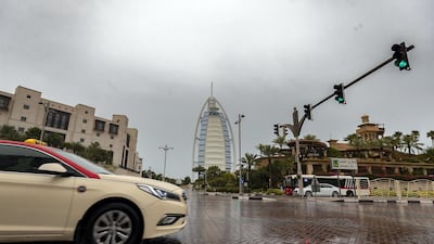 A taxi drives passes the Burj Al Arab as the rain comes down in Dubai. Chris Whiteoak / The National