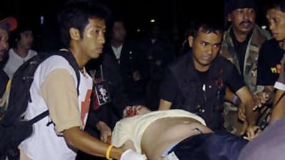An injured anti-government protester is wheeled on a stretcher to a waiting ambulance after a bomb attack at their protesting ground of government house in Bangkok, Thailand Saturday, Nov 22 2008. A grenade attack on protesters occupying the Thai prime minister's office wounded eight people early Saturday, officials said.