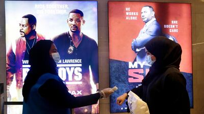 A Saudi movie viewer has her temperature taken at VOX Cinema hall in Jeddah, Saudi Arabia after the announcement of easing of lockdown measures. AP Photo