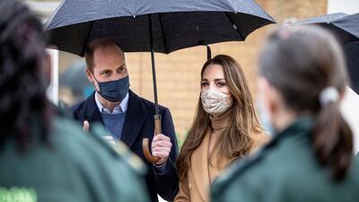 Prince William and Catherine, Duchess of Cambridge hold a discussion with members of the ambulance service. AFP
