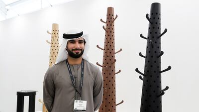 Emirati designer Omar Al Gurg at Downtown Design with his wooden stands that can be used to hang clothes and hats