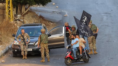 Hezbollah supporters drive past Lebanese soldiers as the army takes up positions amid clashes in the Khalde area, south of Beirut.