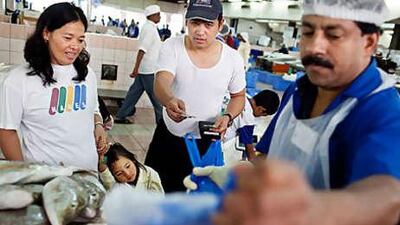 Elisabeth and Jason Tolentino, from the Philippines, haggle for the freshest fare.