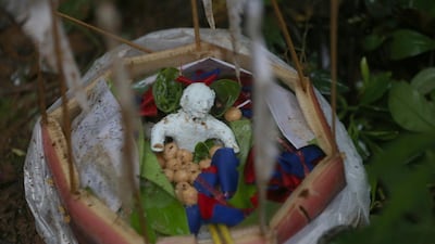 Relatives make a effigy offering food. Sakchai Lalit / AP Photo