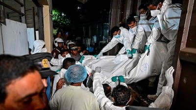 Healthcare workers in Galle carry the bodies of sailors from the Iranian naval frigate IRIS Dena. AFP