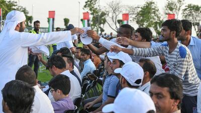 Caps are handed out at the International Worker's Day event on Saadiyat Island.