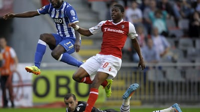 Porto’s forward Silvestre Varela, left, jumps over Braga’s goalkeeper Eduardo, centre, beside Braga’s defender Nurio Fortuna after scoring a goal during the Portuguese league football match SC Braga vs FC Porto at the AXA stadium in Braga on April 13, 2014. AFP PHOTO / MIGUEL RIOPA