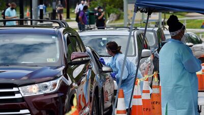 People get free Covid-19 tests in the US. The OECD says the global economy could shrink 7.6 % in the absence of a vaccine. AFP