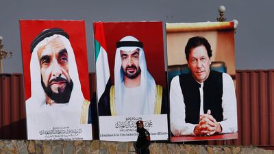 A police commando walks past the huge billboards showing the portraits of Sheikh Mohamed bin Zayed, former President of the United Arab Emirates Sheikh Zayed, and Imran Khan. AP Photo/Anjum Naveed