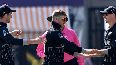 New Zealand's Glenn Phillips celebrates with teammates after taking the wicket of Australia's David Warner. AFP