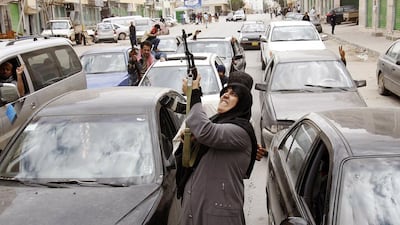 A woman fires an AK-47 rifle as she reacts to the news of the withdrawal of Libyan leader Muammar Gaddafi's forces from Benghazi on March 19, 2011. Goran Tomasevic / Reuters