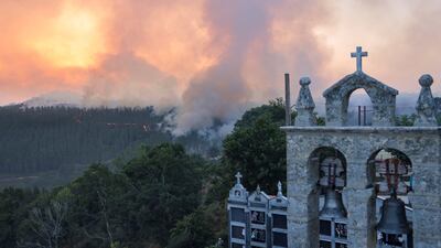 Smoke rises from a wildfire near a cemetery in As Fermosas, in the Ourense province, Galicia, Spain. Reuters
