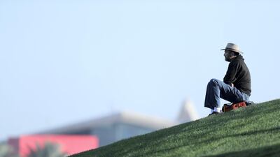 A spectator watches the action on a grass bank.