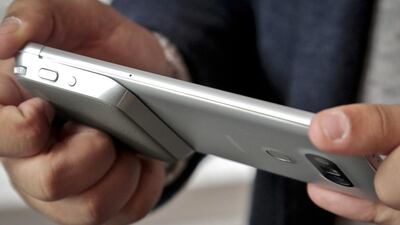 A camera grip, at bottom left, with physical buttons to take the photos and record video on the LG G5 phone. Bebeto Matthews / AP Photo