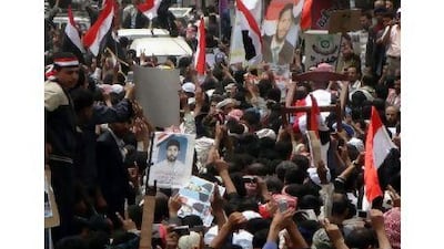 The flag-draped body of a man who died after being injured in a demonstration last month is carried during his funeral in Ibb, Yemen yesterday.
