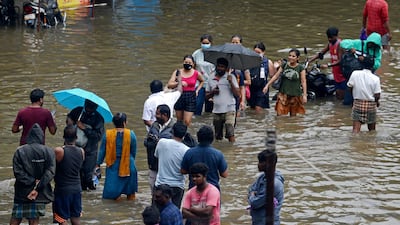 Residents wade along a street after the North-East monsoon brought 12 hours of heavy rain to Chennai. AFP