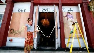 Magazine Street, New Orleans retail employees prepare for Tropical Storm Isaac by putting plywood over their windows.