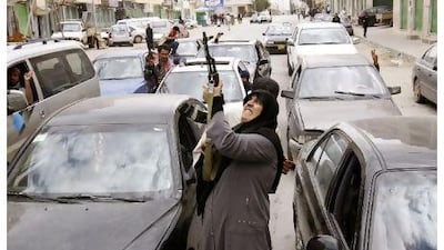 A woman rebel fighter supporter shoots an AK-47 rifle as she reacts to the news of the withdrawal of Libyan leader Muammar Qaddafi's forces from Benghazi.