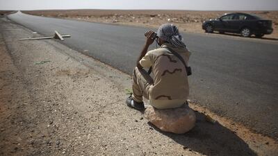 A rebel fighter guards the highway leading to Bani Walid, at a checkpoint in Wadi Dinar, Libya, in 2011. Times have changed since then. (Alexandre Meneghini / AP)