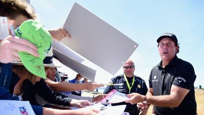 Phil Mickelson, right, of the United States signs his autograph for fans during a practice round prior to the start of the 115th U.S. Open Championship at Chambers Bay on June 16, 2015 in University Place, Washington. Harry How/Getty Images