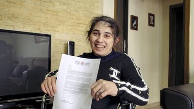Rita Hajjar, 43, holds her invitation to the Special Olympic World Games in her new apartment in Beirut, courtesy of the UAE. Adib Chowdhury for The National