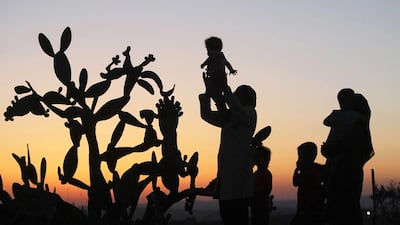 Members of the al-Nawajaa family are seen at dusk near a cactus plant in the area where they live, near the Jewish settlement of Sosia and the Palestinian village of Yatta, in the West Bank, 01 July 2012. The Palestinians in this area received notice that Israel intends to demolish their structures in the near future. EPA/ABED HASHLAMOUN