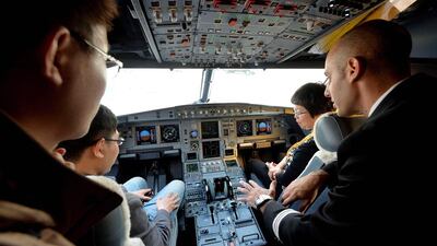 Airbus flight engineer Luke Mifsud, right, explains the cockpit controls on a A319 private business jet to Chinese potential customers. The country will account for roughly 9 per cent of the worldwide business jet fleet in 2032, up from less than 2 per cent in 2012, according to Bombardier. Mark Ralston / AFP