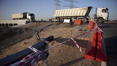 Trucks pass by the scene of a traffic accident on February 4, 2013 involving a truck and a bus full of laborers that left 22 people dead about 35km from Al Ain on the Abu Dhabi - Al Ain road. Silvia Razgova / The National