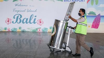 A quarantine officer at Bali's international airport. The holiday island is officially open to travellers from overseas again, but it's not quite so easy to travel there. EPA