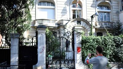 A French security officer takes a photograph outside the Iranian Embassy in Paris on September 14, 2018, after protesters sprayed red paint on the Embassy sign and trashed computers that were placed outside the embassy grounds for collection. AFP