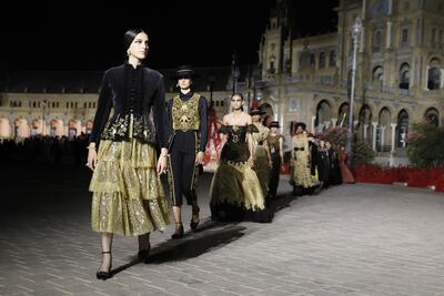Models showcase designs featuring heavy gold embroidery as part of Dior Cruise 2023. EPA