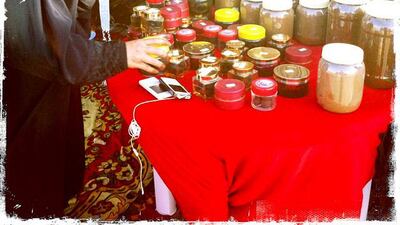 Day trip with friends to the Western Region and the Mazayin Dhafra Camel Festival, 220 kms west of Abu Dhabi on December 20, 2013. A merchant organizes her wares at the traditional souk. Picture taken with the Hipstamatic app for the iPhone. Liz Claus / The National