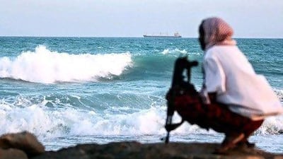 A Somali pirate keeps watch on the coastline near Hobyo, northeastern Somalia. AFP
