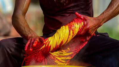 A worker dyes a batch of Kalawa threads in Allahabad. AFP