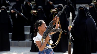 A girl holds a rifle in front of women during a parade in Sanaa, Yemen on September 6, 2016. The easy access to weapons in Yemen puts children and innocent bystanders in harm's way. Khaled Abdullah/Reuters