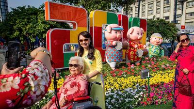 Vietnamese women pose for photographs in front of pig figurines at the Nguyen Hue flower street, decorated for the upcoming Lunar New Year or Tet celebrations in Ho Chi Minh City. AFP