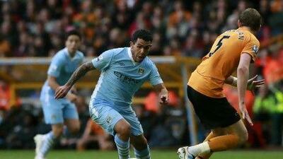 Manchester City's Carlos Tevez, centre, takes the ball past Wolverhampton Wanderers' Richard Stearman.
