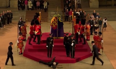 A Royal guard collapses in front of Queen Elizabeth's coffin.