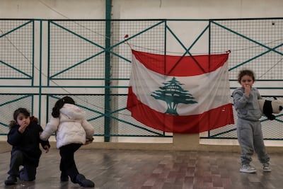 Children play near a Lebanese flag hung in a school now used as a temporary shelter for displaced people. Reuters