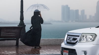 A woman captures views of the Abu Dhabi Corniche with her phone. Victor Besa / The National