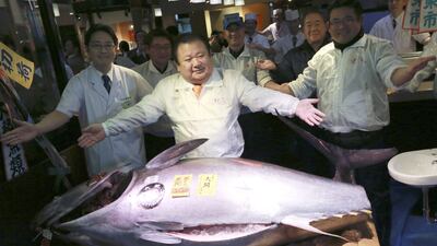 Kiyoshi Kimura, centre, the president of Kiyomura, poses with a bluefin tuna at his Sushizanmai restaurant near Tsukiji fish market in Tokyo. The Japanese sushi chain boss bid a winning Dh2.2 million for the 212 kilogram fish. Eugene Hoshiko / AP